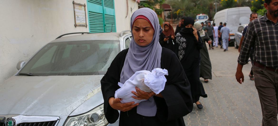 A woman carries the body of a newborn killed in an attack on Nasser Hospital in Khan Younis, Gaza. A woman carries the body of a newborn killed in an attack on Nasser Hospital in Khan Younis, Gaza.