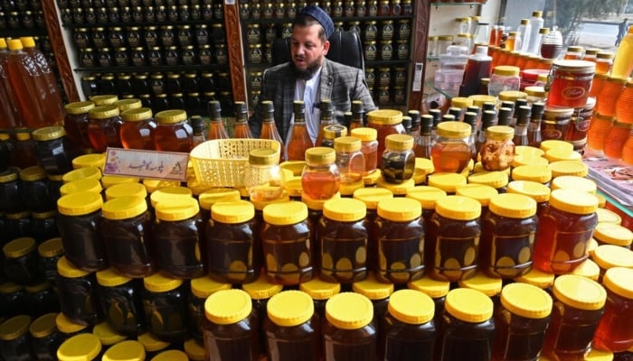 A honey supplier is waiting for customers the market in Chamkanni on the outskirts of Peshawar. - AFP/file