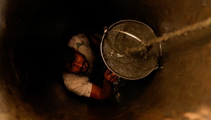 A man cleans a small well in Chandrapur, India, 3 February 2025. - Reuters