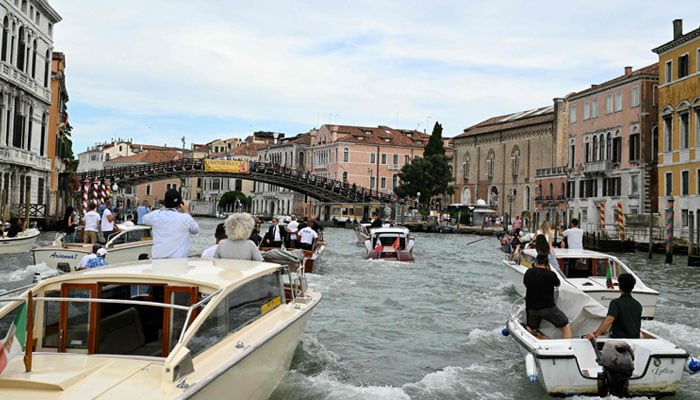 The boat MOA is transporting Amazon's founder Jeff Bezos escorted on the Grand Canal on his wedding day in Venice on June 27, 2025. - AFP