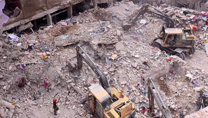 Rescue workers are busy in operation at the collapsed construction site in Bagdadi, Lyari, as several bodies are recovered from the waste. - App/file