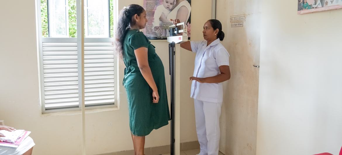 A nurse controls a pregnant woman's weight and vital signs of a galigamuwa clinic, Sri Lanka.