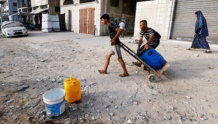 A boy draws a container on a wagon when Palestinians are waiting to collect water in the middle of deficiency in the middle of deficiency, in Gaza City August 6, 2025. - Reuters