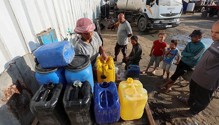 Palestinians collect water in the midst of the lack of a distribution point in Deir al-Balah in Central Gazastrip 5 August 2025.-Reuters