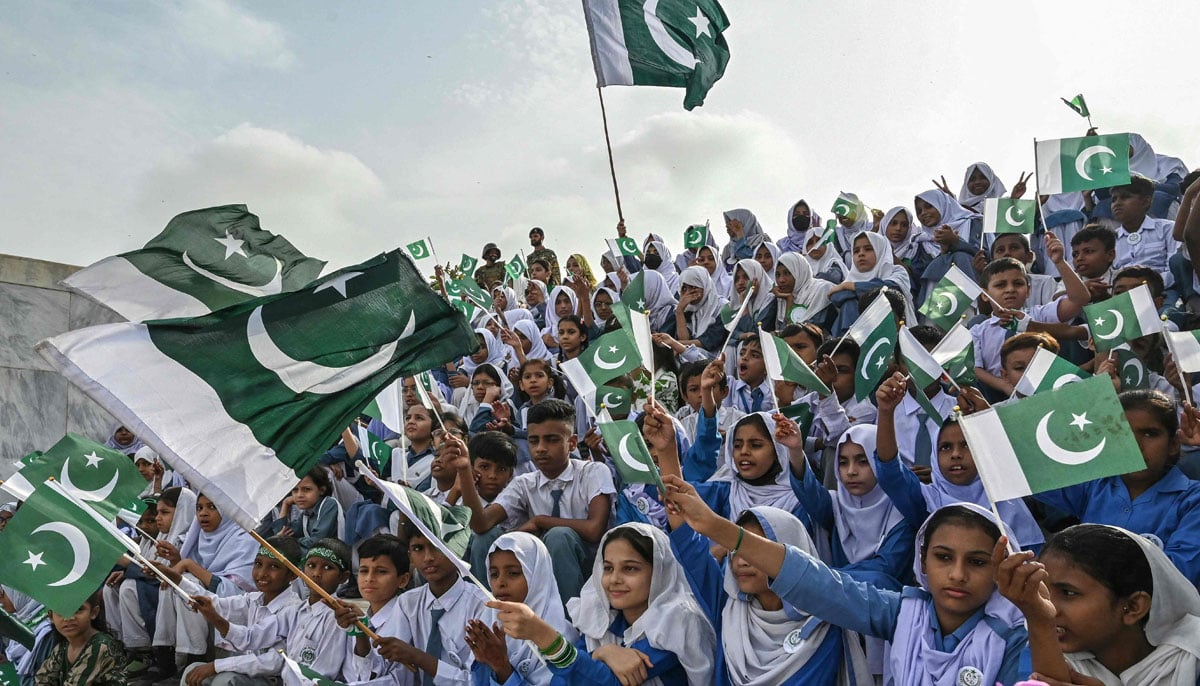 Students waving national flags during Independence Day Celebration at Mausoleum in Muhammad Ali Jinnah, in Karachi on August 14, 2025. - AFP