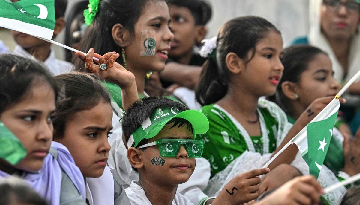 Students waving national flags during Independence Day Celebration at Mausoleum in Muhammad Ali Jinnah, in Karachi on August 14, 2025. - AFP