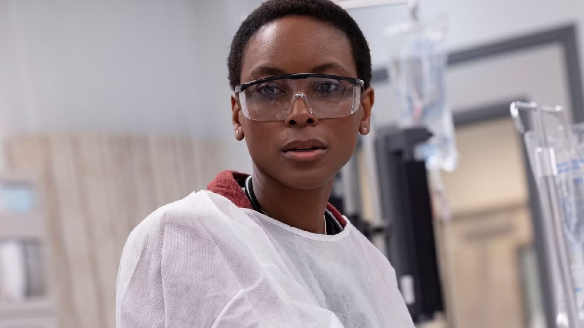 Dr. Collins wearing surgical robes and glasses and looking at