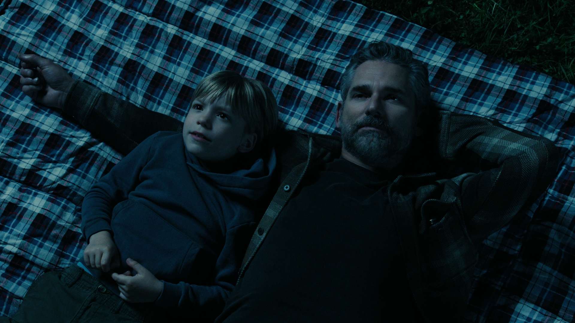 Kyle is lying on a picnic rug with his son, Caleb, in untamed season 1