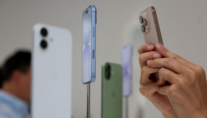 A person uses a phone to catch iPhones exhibited during apples -event at Steve Jobs Theater in Cupertino, California, USA, September 9, 2025. - Reuters