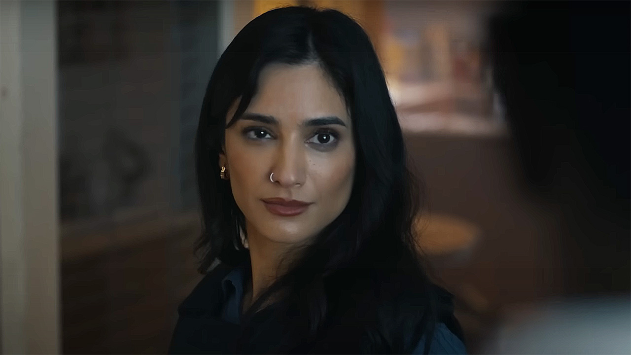 Sasha Bordeaux half smiling on any off-camera in Peacemaker season 2