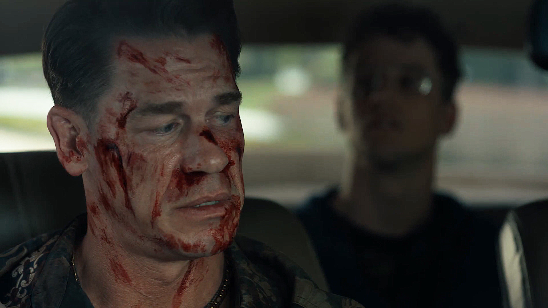 A Bloody Chris Smith looks behind him on Adrian Chase/Vigilante in Peacemaker Season 2 Section 5