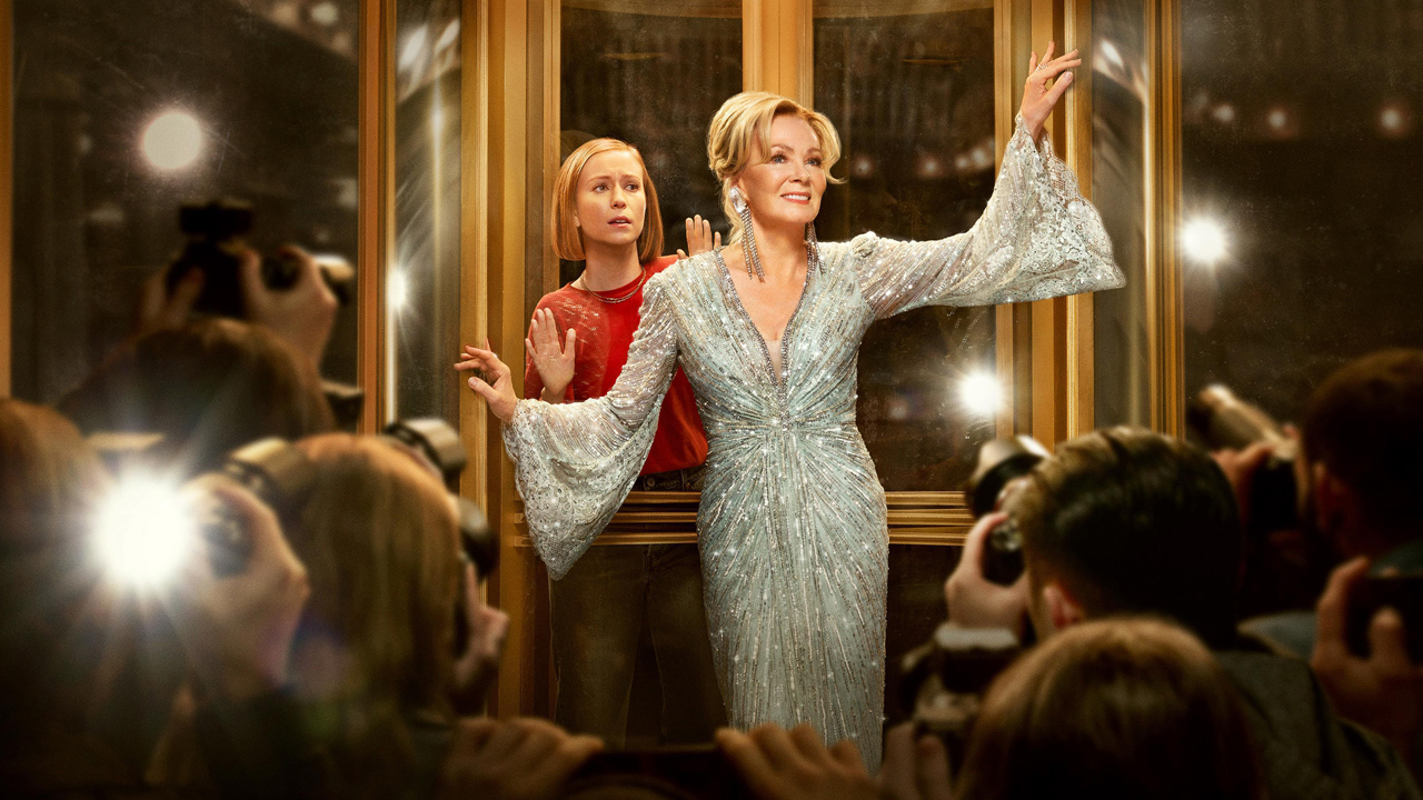 Ava caught in a rotating door as Deborah is snapping by the paparazzis in Hacks Season 3