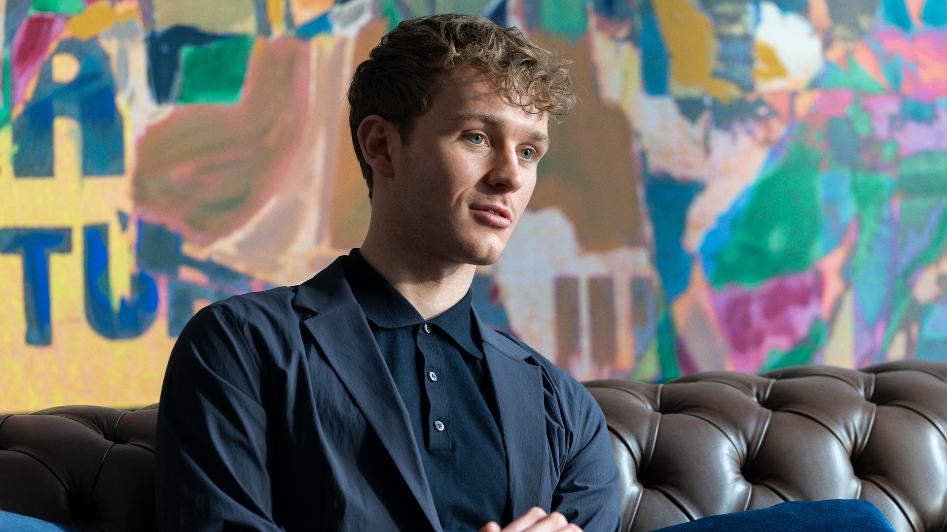 Rob sitting on a sofa in the industry season 3