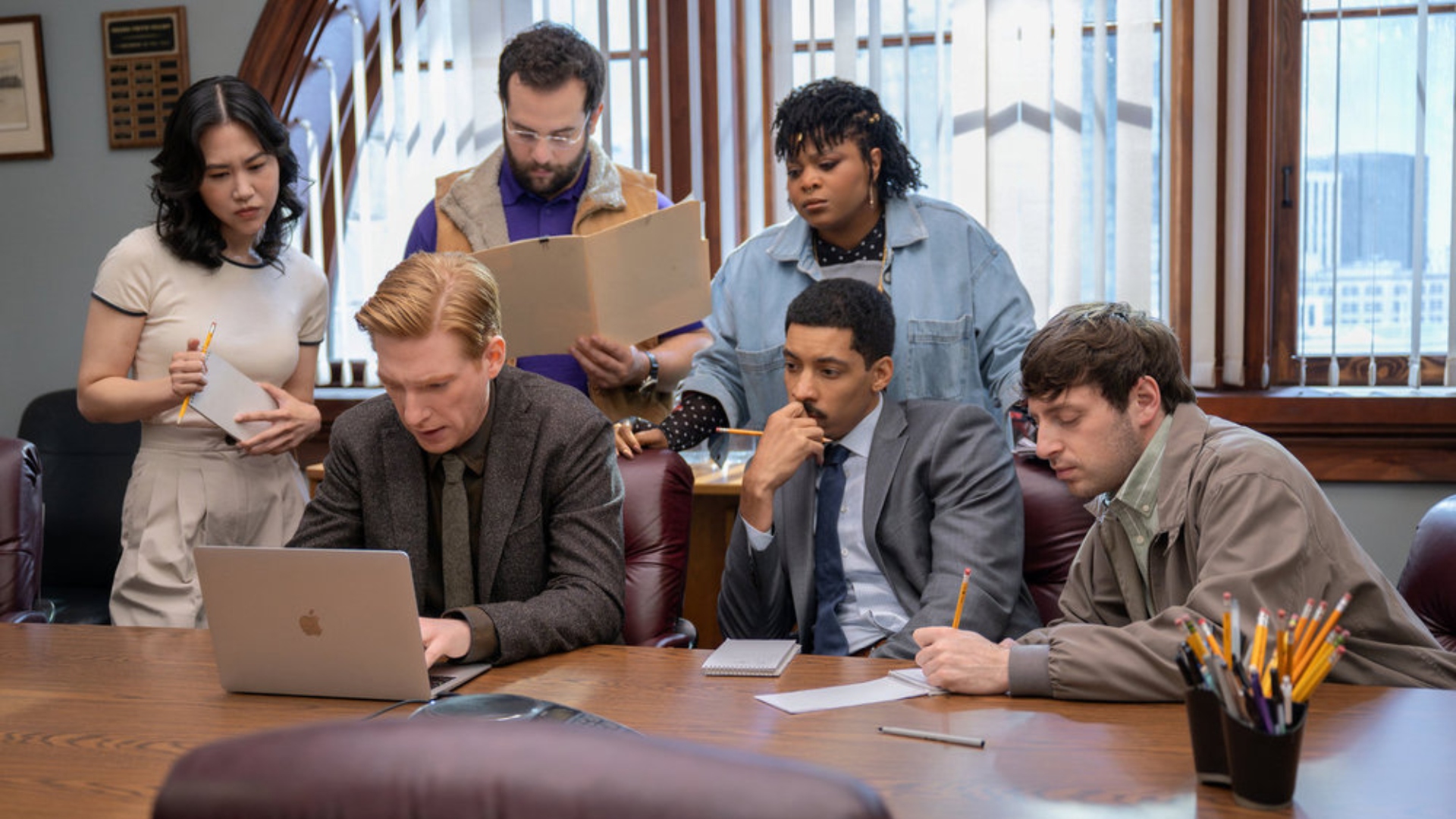 The staff gather around a laptop in paper season 1
