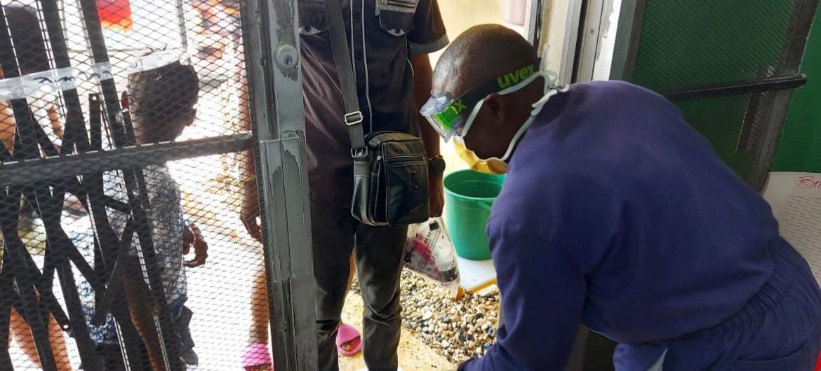 A health worker performs sanitation procedures when people enter a cholera facility in Haiti.