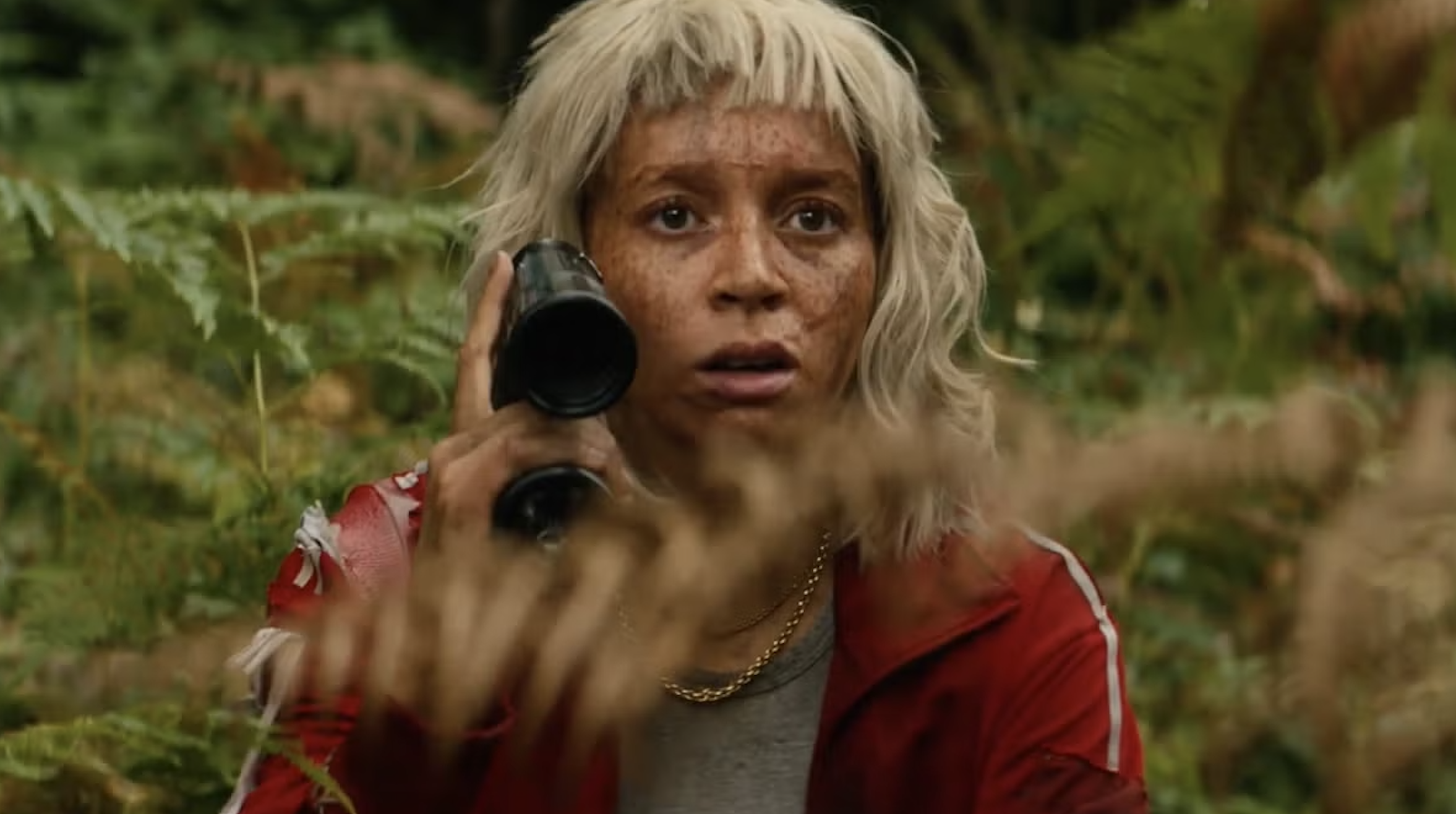 Alfie Williams like spikes, wearing a blond wig and red training suit