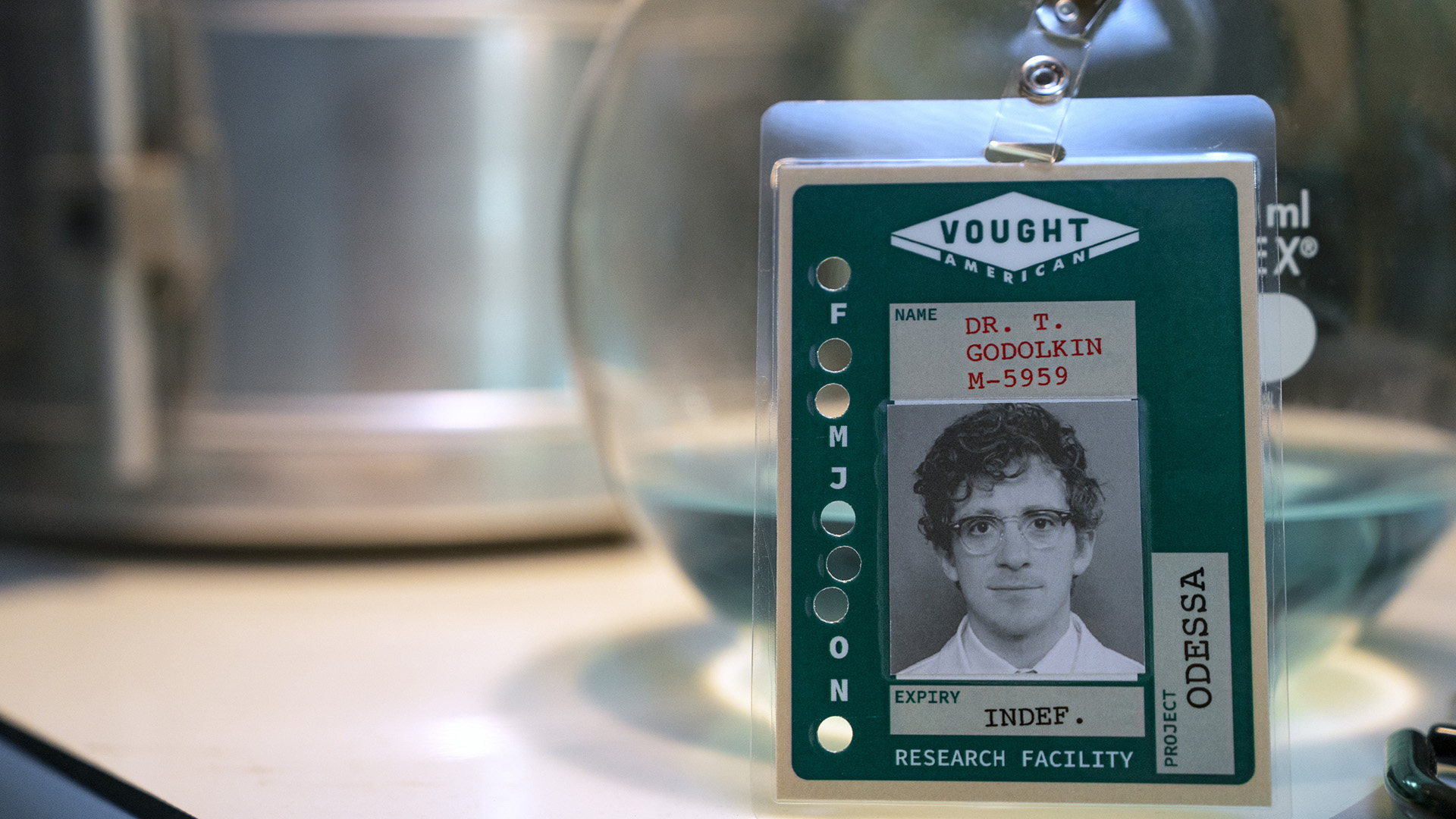 A Screenshot of Doctor Thomas Godolkin 's Nametag -badge supported on a table in Gen V Season 2