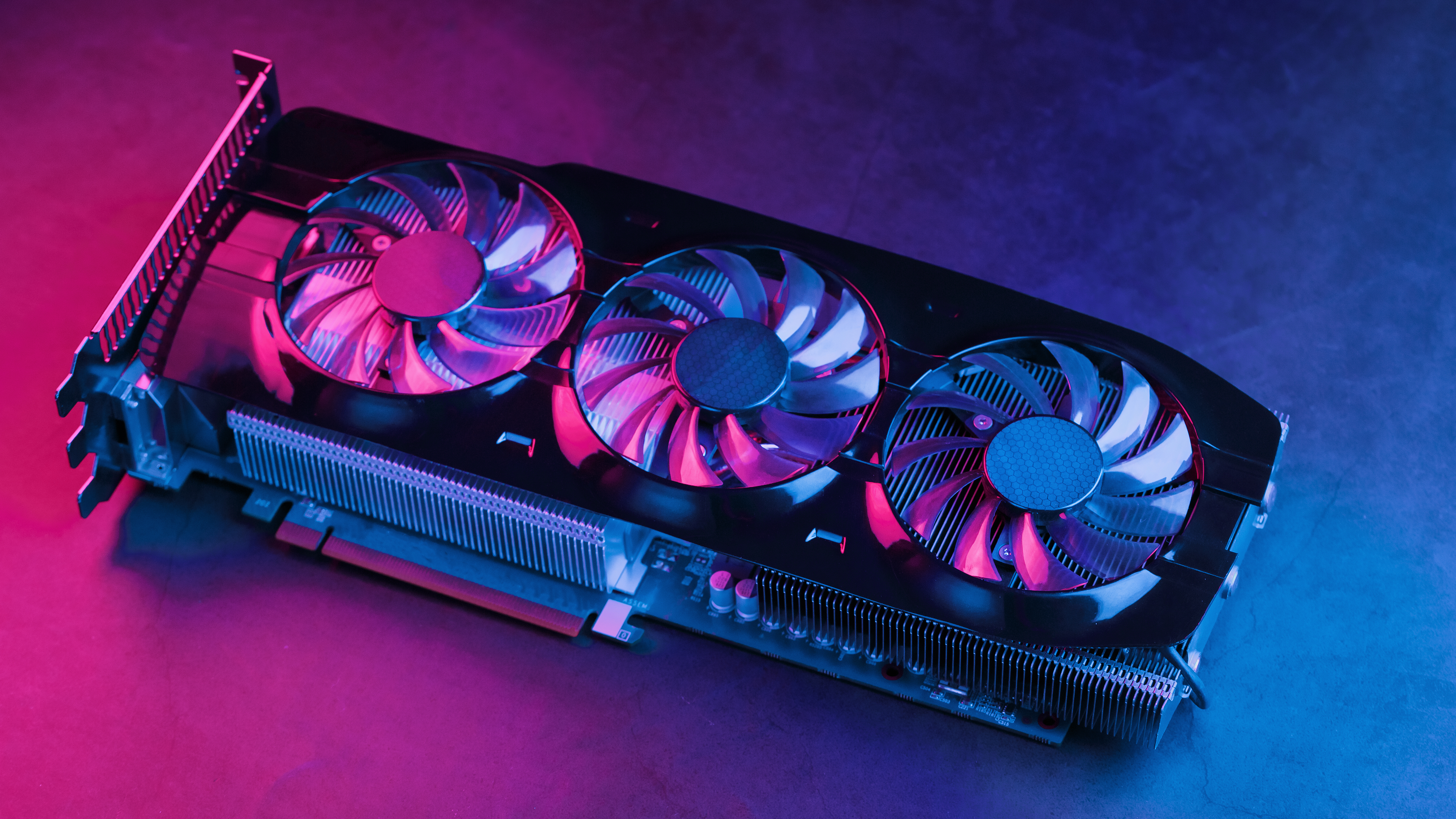 A graphics card on a table in pink and blue lighting