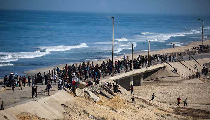 Palestinians gather on a street in the NUSEIRAT in Central Gazastrip on October 10, 2025. - AFP