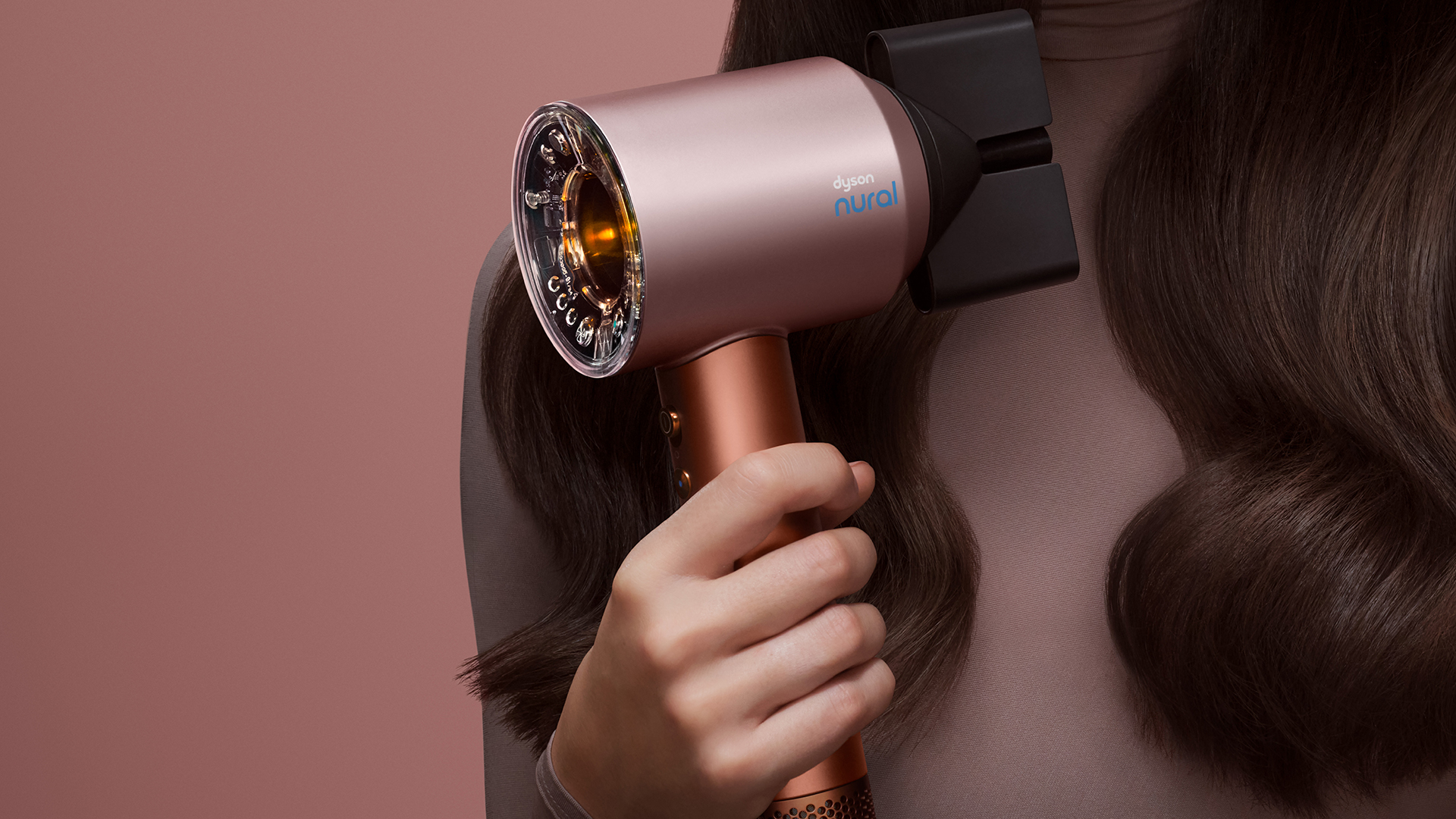 Woman using Dyson hair tool in Amber Silk colorway
