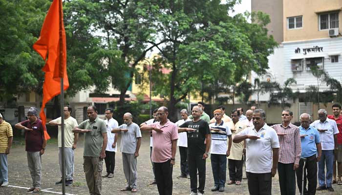 Rashtriya Swayamsevak Sangh (RSS) volunteers salute the organization's flag before morning exercises during a shakha or training session of the Hindu nationalist organization at a park in Nagpur on October 3, 2025. — AFP
