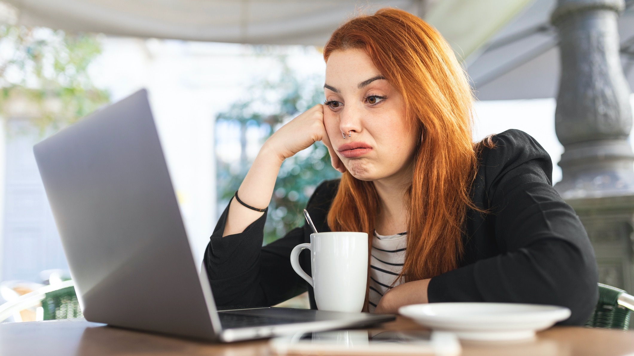Young woman using laptop looking annoyed
