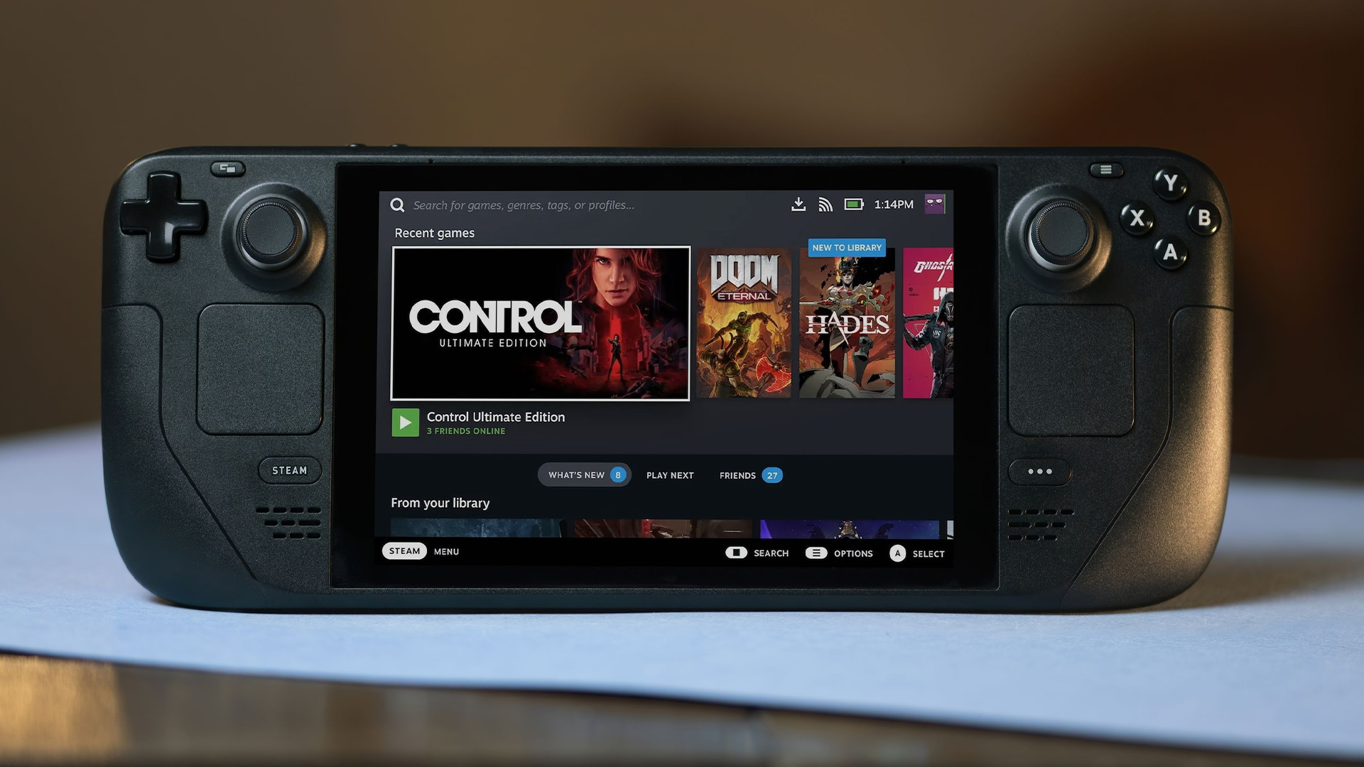 Steam Deck on a desktop showing the home screen