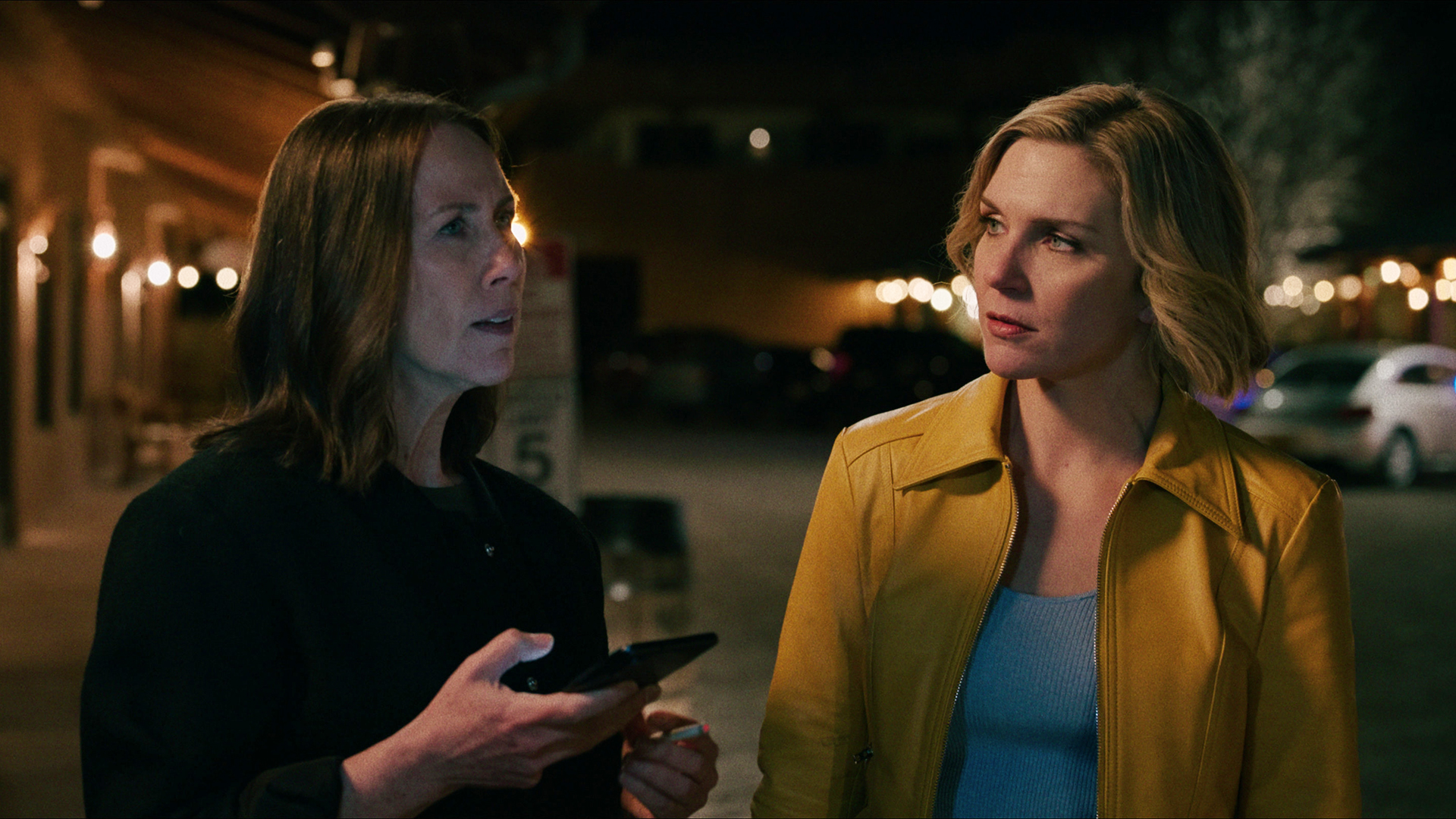 Helen holds her phone while Carol looks at her in Pluribus episode 1