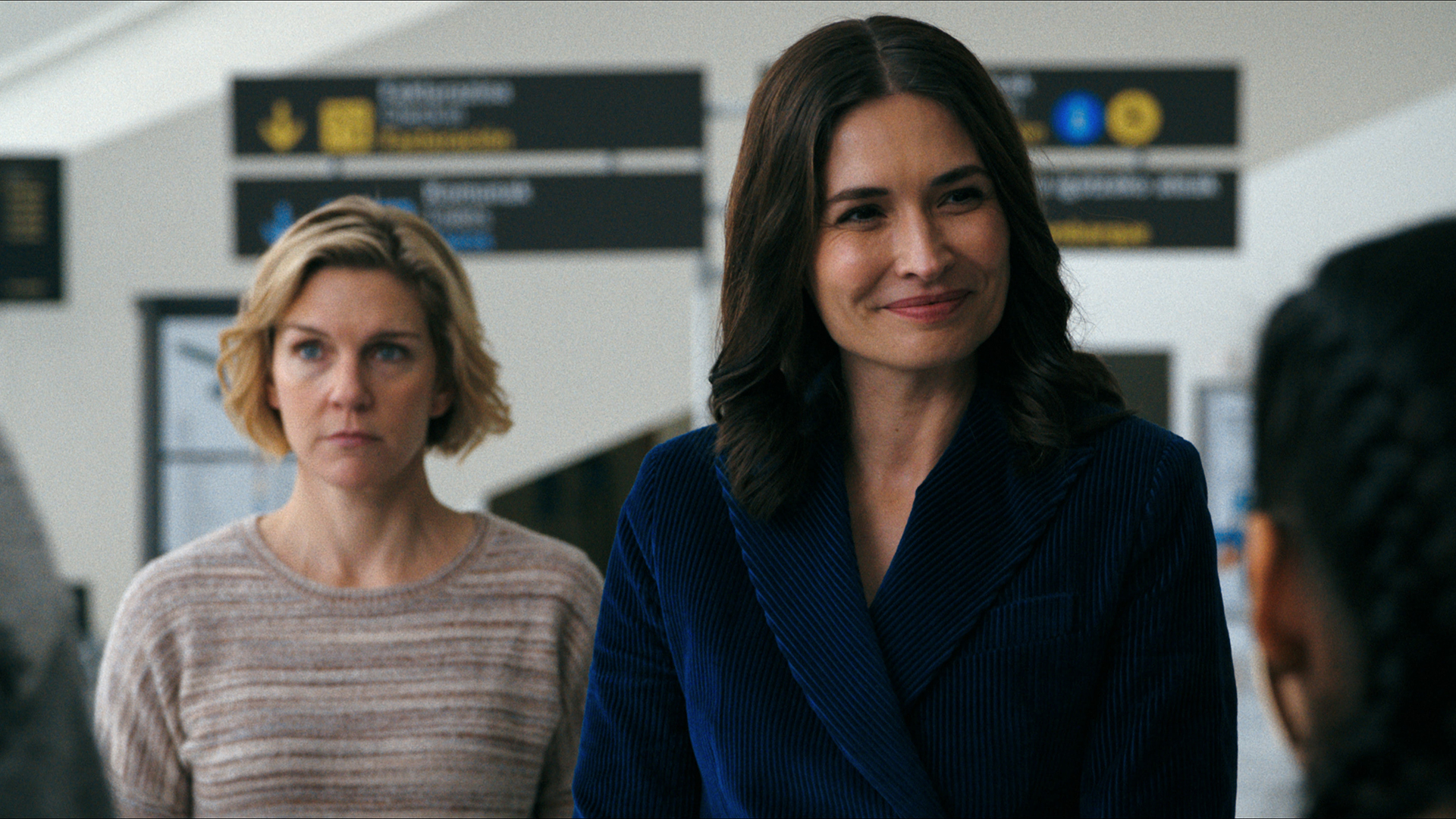 Carol stands behind a smiling Zosia in Pluribus episode 2