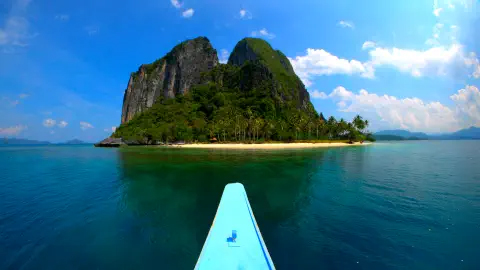 A canoe approaches an island in calm water