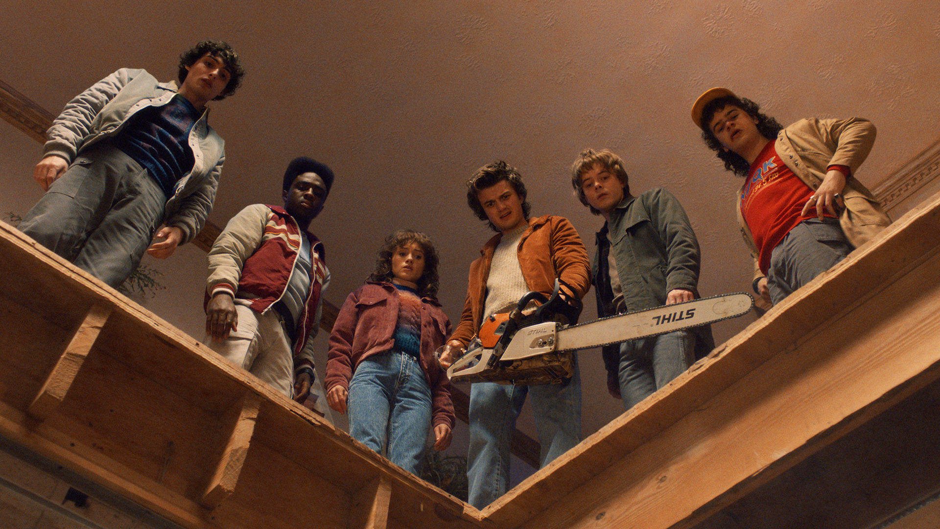 Mike, Lucas, Nancy, Steve, Jonathan and Dustin look down from a roof in Stranger Things Season 5