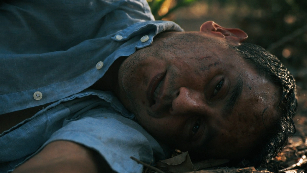 A nearly dead Manousos lying on the rainforest floor in Pluribus episode 7