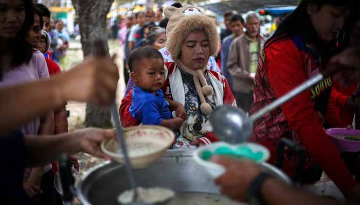 Displaced people queue for food at a school that has become a temporary shelter amid clashes between Thailand and Cambodia along a disputed border area in Surin province, Thailand. - Reuters