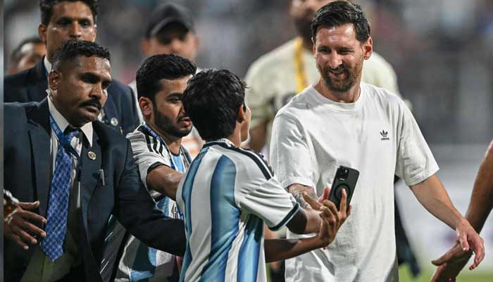 Argentina soccer player Lionel Messi (R) interacts with a young fan during his Goat Tour at the Wankhede Stadium in Mumbai on December 14, 2025.— AFP