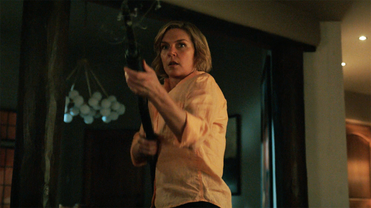 Carol brandishes a shotgun in a house at night in Pluribus episode 9