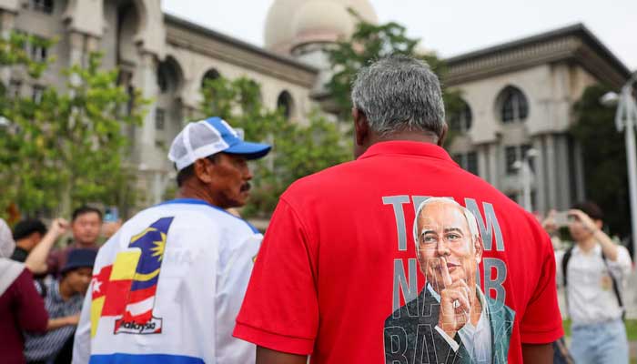 A supporter wears a shirt with former Malaysian Prime Minister Najib Razak's portrait printed on it outside the Palace of Justice in Putrajaya, Malaysia on December 26, 2025. — Reuters