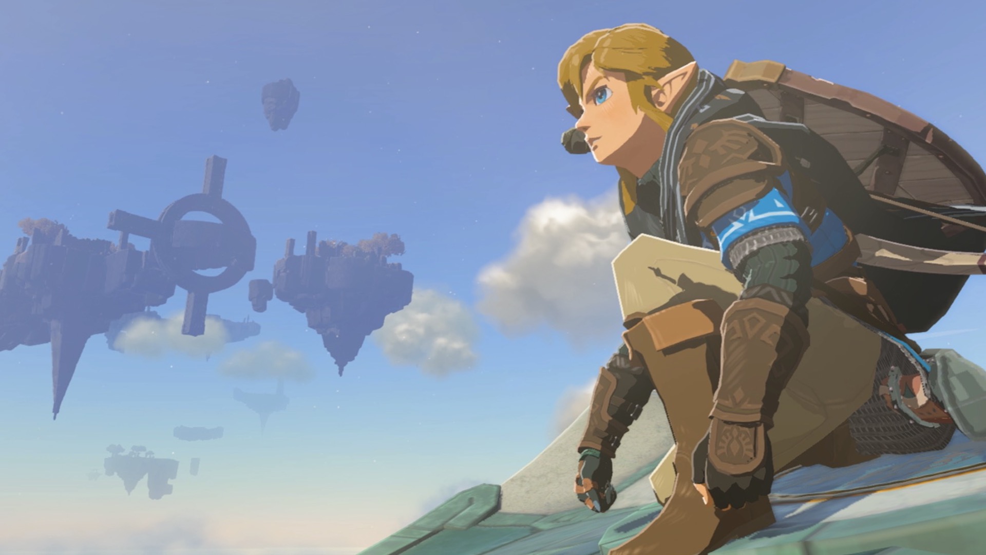 Link crouches down and looks out over Hyrule. A sky island can be seen floating in the background