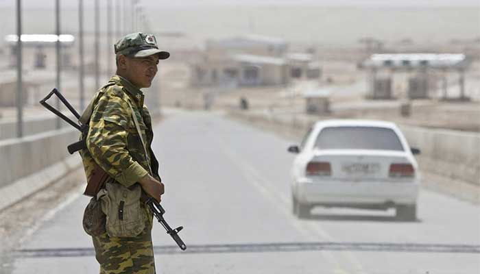 A border guard stands on a bridge to Afghanistan over the Panj River at the Panji Poyon border post, south of Dushanbe, Tajikistan, May 31, 2008. — Reuters