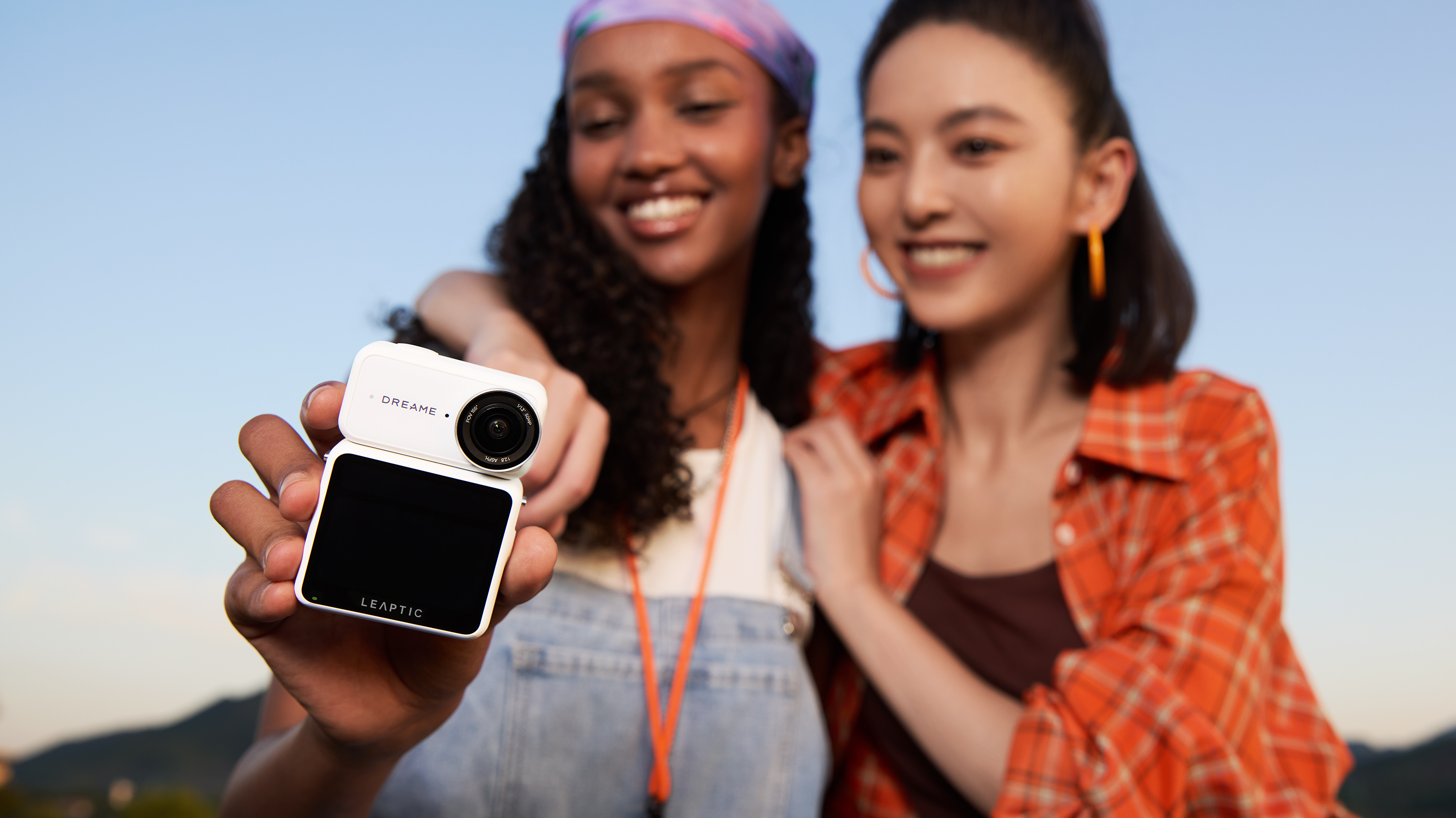 Dreame Leaptic Cube action camera held by a woman posing with another woman