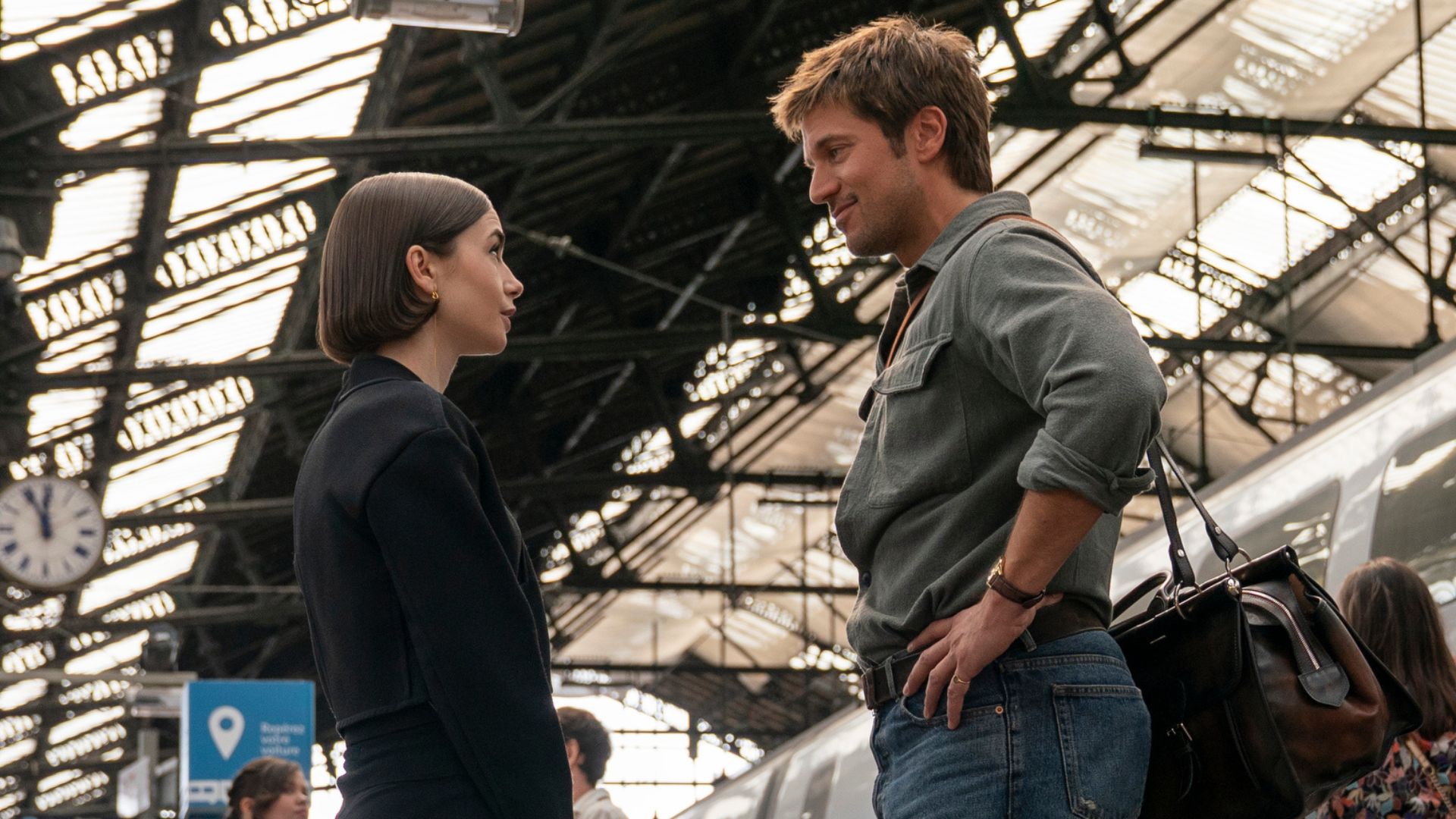 Emily and Gabriel are talking on a train platform