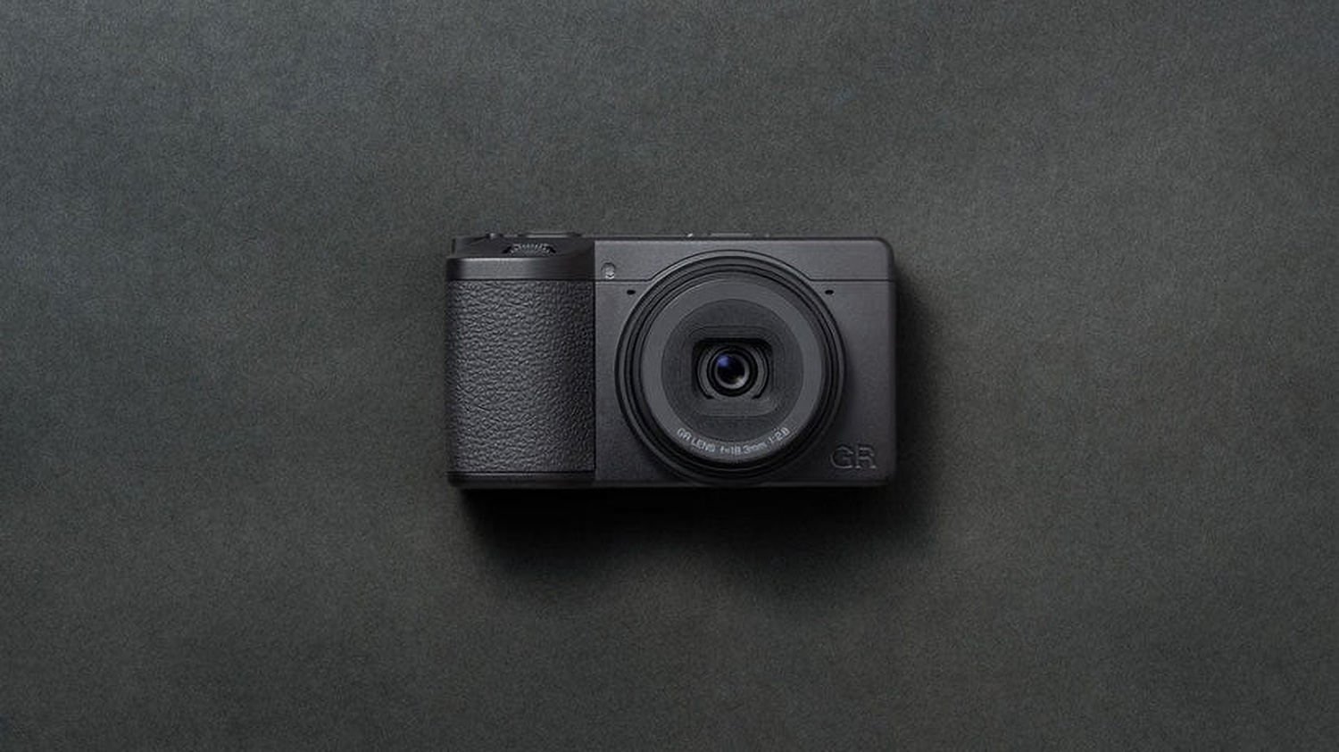 Ricoh GR IV Monochrome compact camera in a studio with a gray background