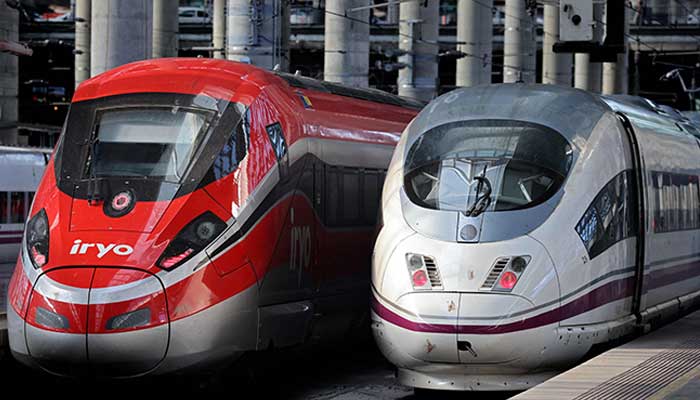 High-speed train AVE of the Spanish national railway company RENFE (R) is seen next to the high-speed train of the private operator Iryo of the ILSA company at the Atocha station in Madrid on February 26, 2023. — AFP