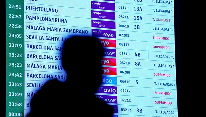 A person walks past an information board at Atocha train station amid train delays and cancellations after a deadly derailment of two high-speed trains in Adamuz near, Cordoba, according to local police reports in Madrid, Spain, January 18, 2026. — Reuters