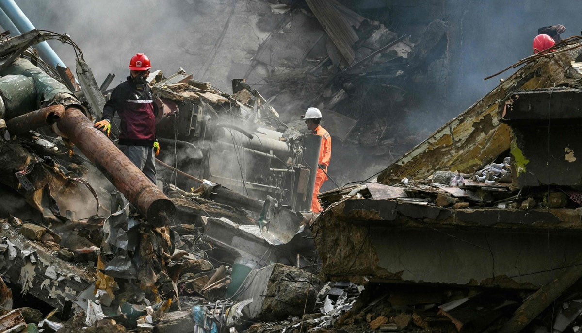 Rescue workers search amid the debris after a massive fire at a shopping mall in Karachi on January 19, 2026. — AFP