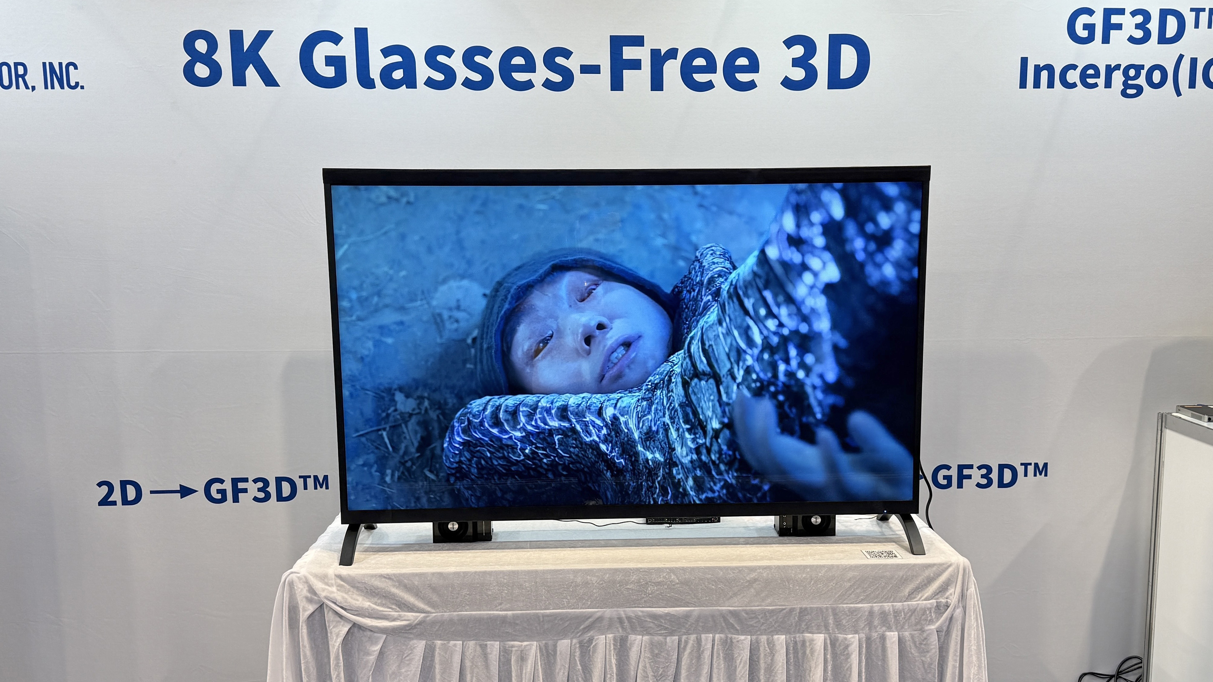 Visual Semiconductor's GF3D TV at CES 2026 showing a man pinned under a monster's foot on screen