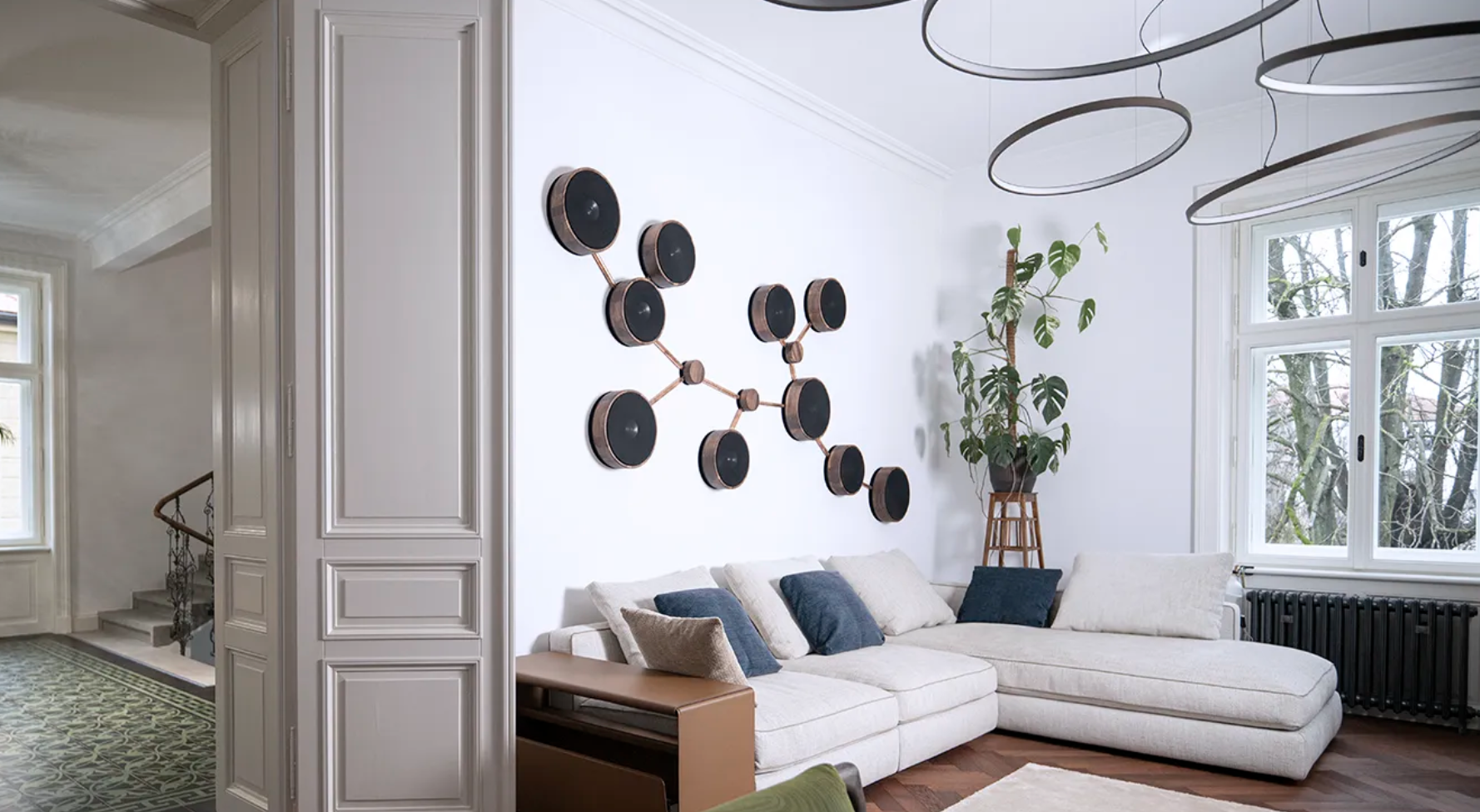 Ultrasonic Molecular Audio system on a white wall showing multiple wall-mounted speakers connected to resemble molecular structures