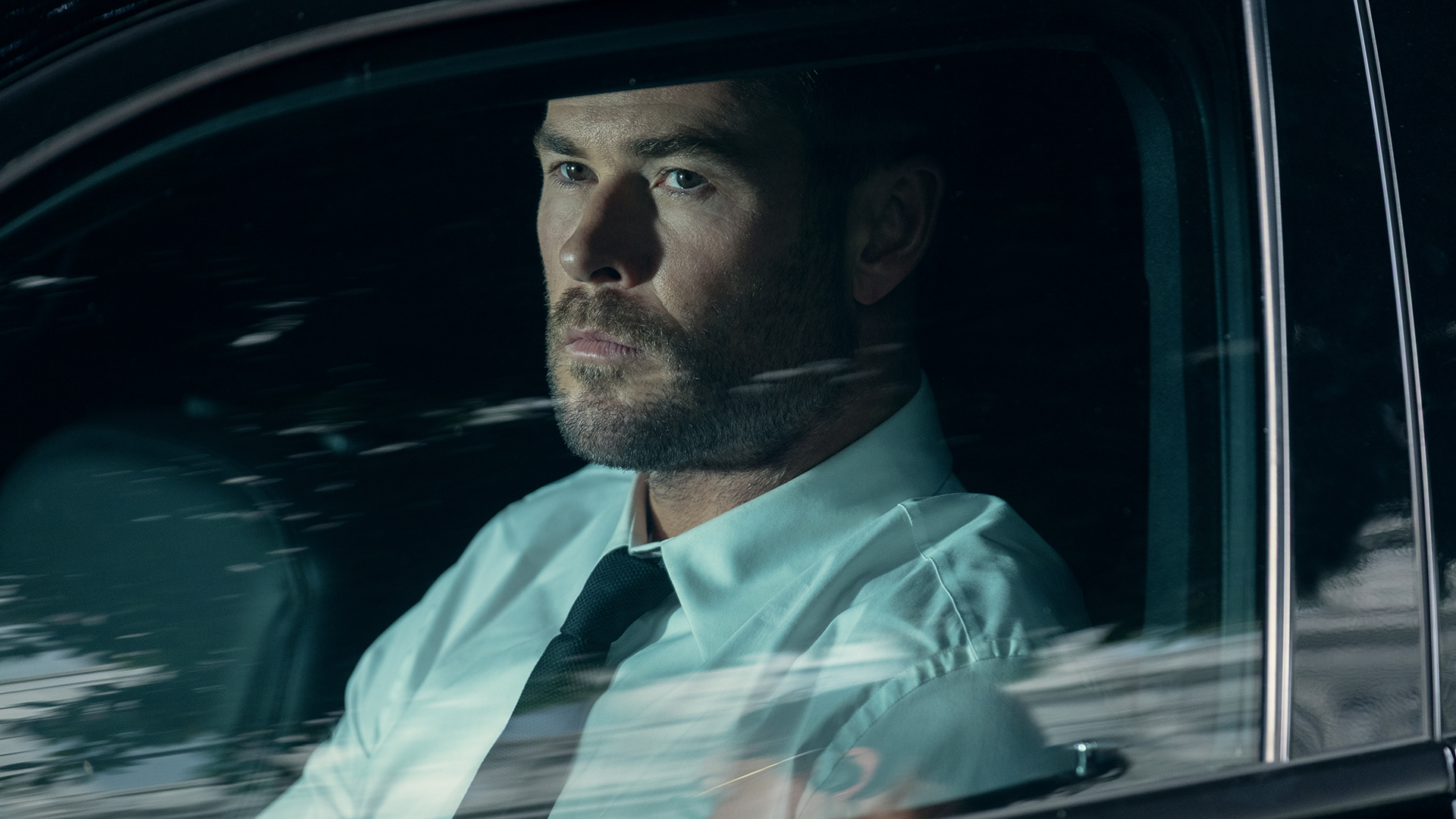 Chris Hemsworth's Davis looks out the driver's side car window in Crime 101