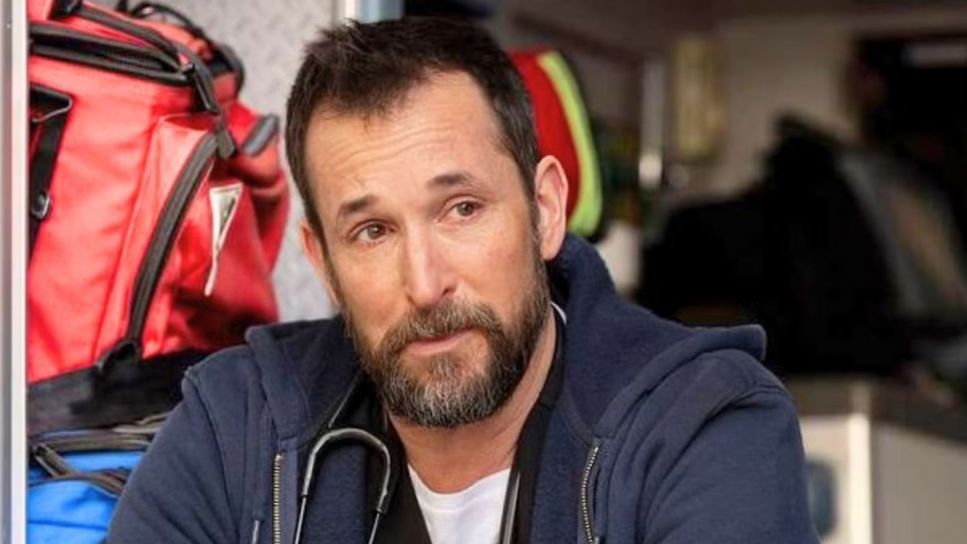 Dr. Robby cries while sitting in the back of an ambulance