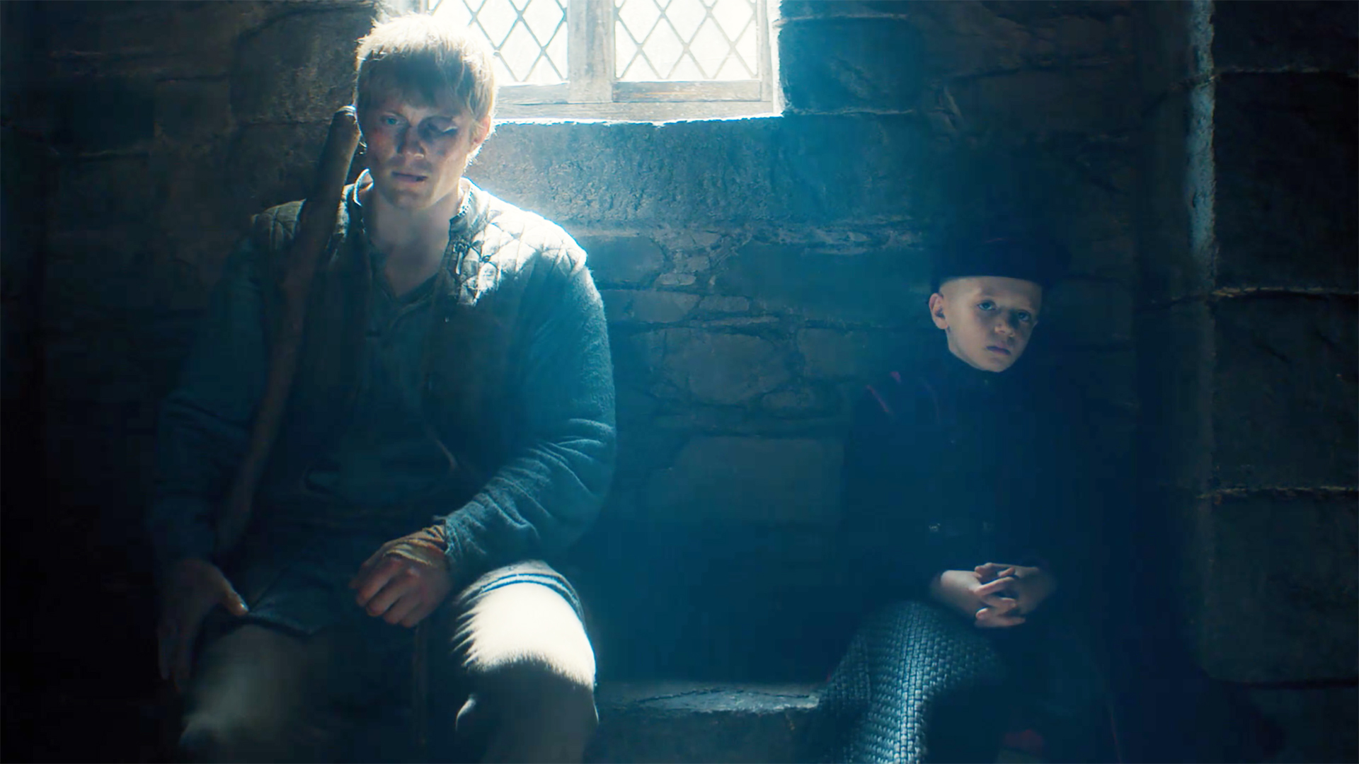 Dunk and Egg sit on a bench inside a building as light pours in from a window in A Knight of the Seven Kingdoms episode 6