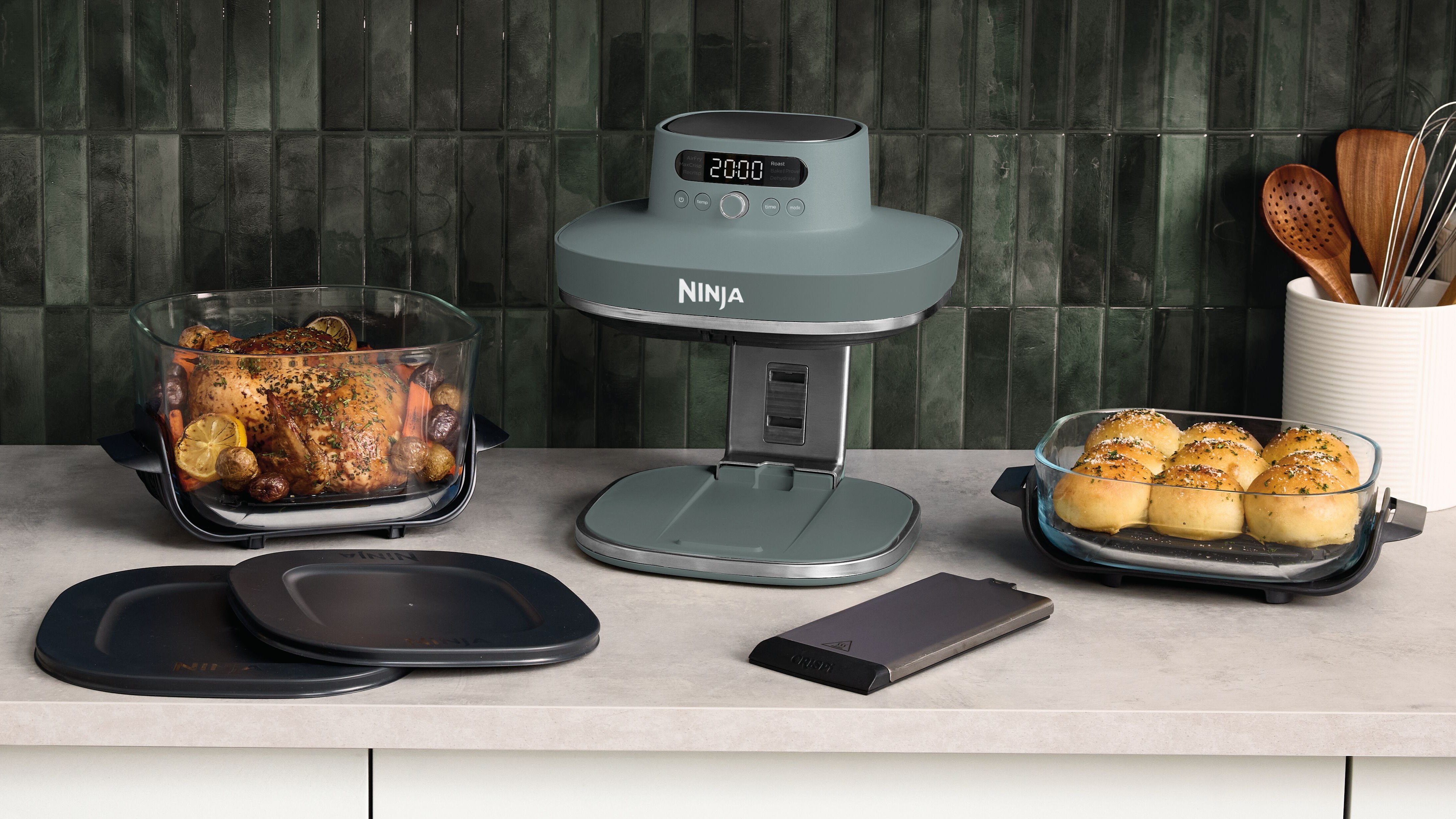 Ninja Crispi Pro air fryer with food and accessories on the kitchen table